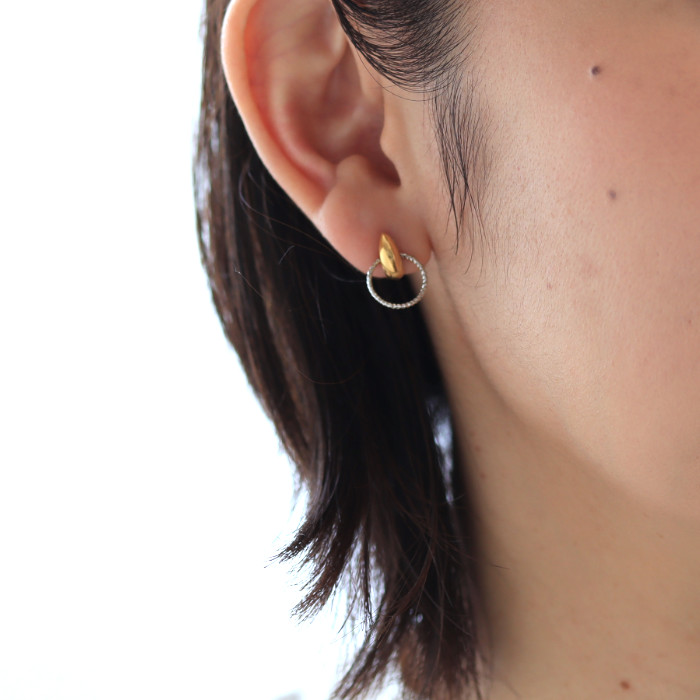 プラチナリングチャームとゴールドカラーの三日月ピアスを耳に着けた女性の耳元画像