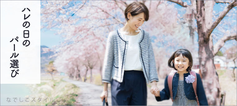 桜を背景にした入学式の格好をした女性と子供の画像