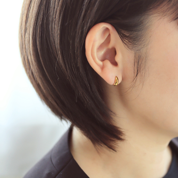 ゴールドチタンカラーの三日月ピアスを耳につけた画像