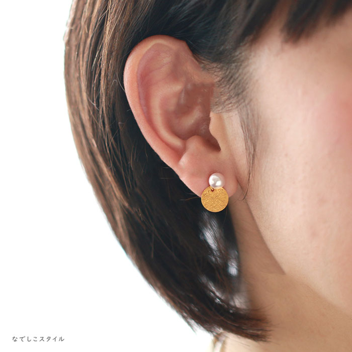 ゴールドカラーのサークルチャームをつけた耳に着けた４０代女性の耳写真