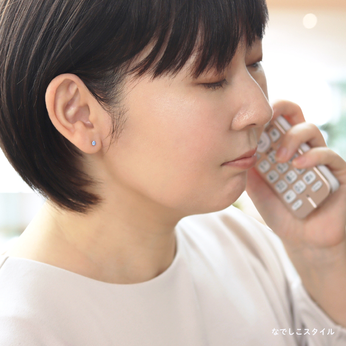 純チタンピアスのアクアマリン３ｍｍを着けた女性がお仕事をしているイメージの画像
