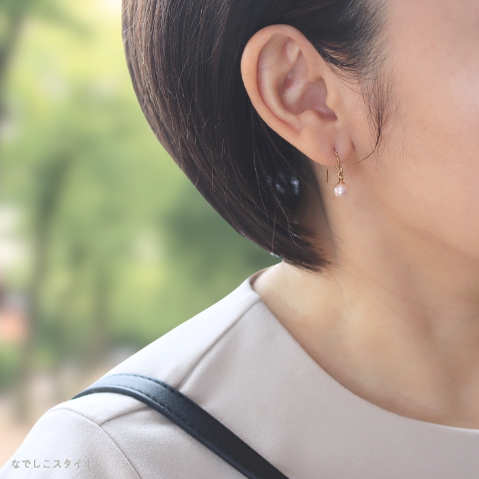 6ｍｍ桜色の一粒グラスパール フックをつけた女性のお仕事写真