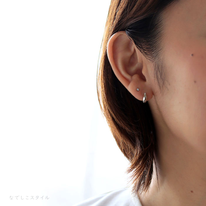 純チタンピアスプラチナカラー三日月と純チタンピアスダイアモンド２ミリを耳に着けている４０代女性の横顔