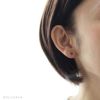 チタン純度99.5％でプラチナ軸のチタンピアス、天然石ラウンド「アイオライト」の女性の耳につけている画像