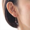 プラチナカラーの純チタンフック使用のティアドロップピアス「マットアメジスト」、女性の耳につけている画像