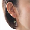 プラチナカラーの純チタンフック使用のティアドロップピアス「マットオリバイン」、女性の耳につけている画像