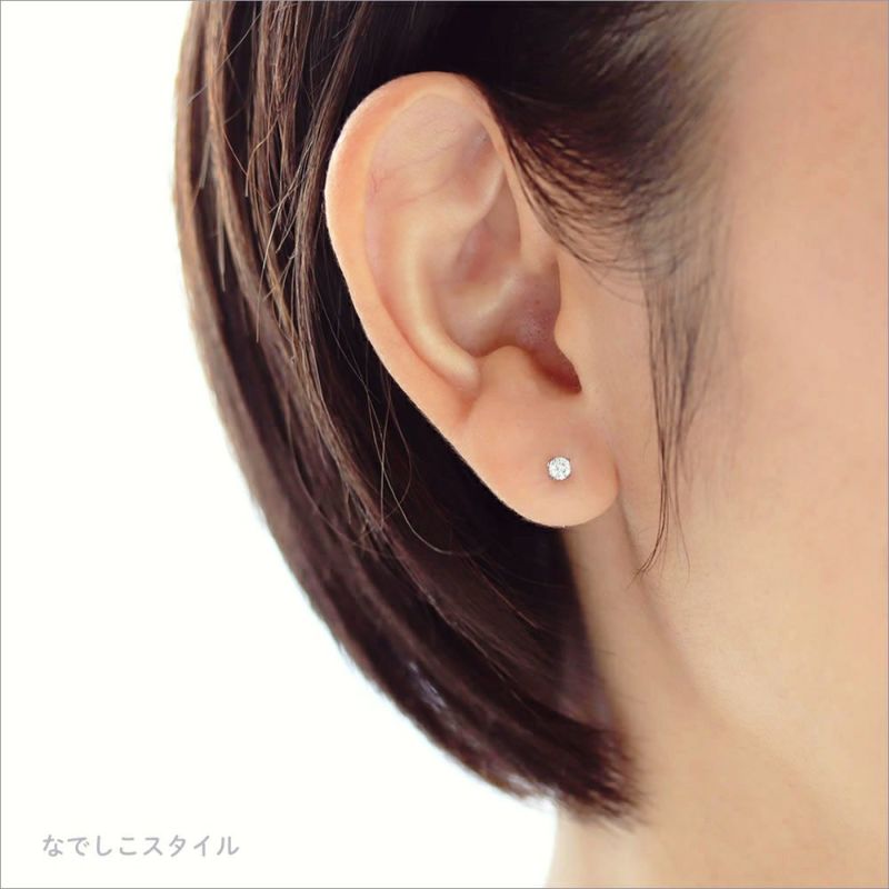 シンプルなダイアモンドカラーの純チタンピアスを着けた40代女性の耳写真