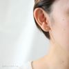 チタンピアス、プラチナ軸の「カルテット/CZダイアモンド」3mm、女性の耳につけている画像