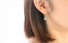 純チタン使用の「アンティークパール/オリーブグリーン８㎜フック」を耳につけた女性の画像