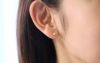 純チタン使用の「天然石 丸玉スタット「ピンク珊瑚」4mm」を耳につけた女性の画像