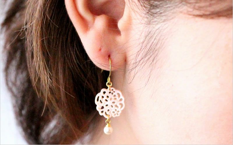 純チタン使用のshell lace 「ピンクシェル」を耳につけた女性の画像