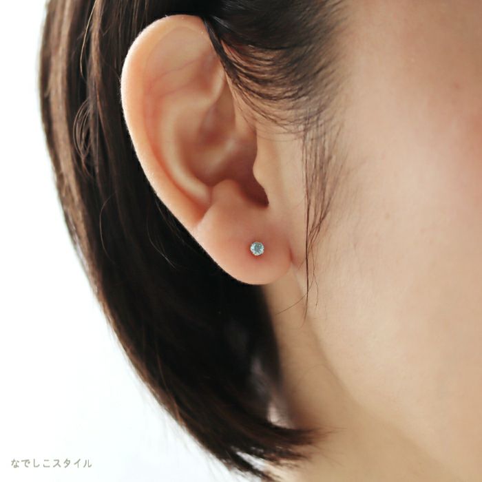 ゴールドカラーのチタンピアス「ミントベリル/3ｍｍ」女性の耳につけている画像