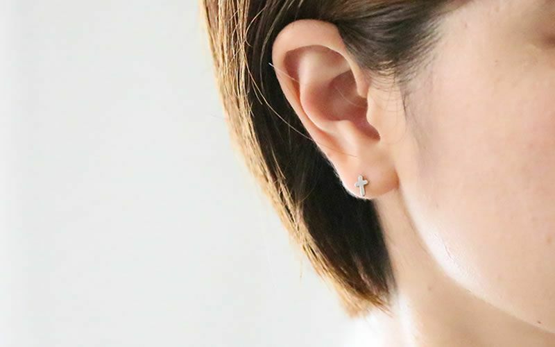 純チタンピアス、オールぴゅあチタンクロス【プラチナカラー】を耳に着けている４０代女性の横顔
