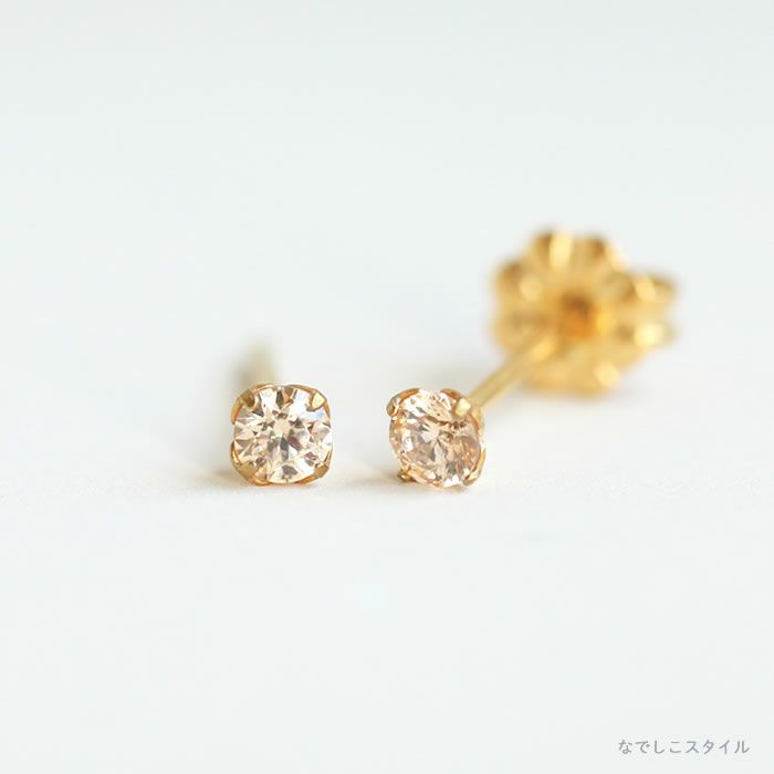 金属アレルギーに安心して使えるチタンピアス、ゴールド軸のスワロフスキー/一粒ジルコニア「ゴールドカラー/シャンパンダイア」3ｍｍの商品を縦斜めに置いた写真