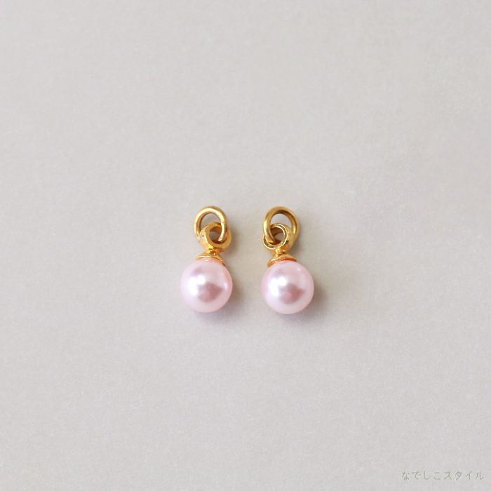 ゴールドカラーの金具を使った桜色パールチャームを置いた画像