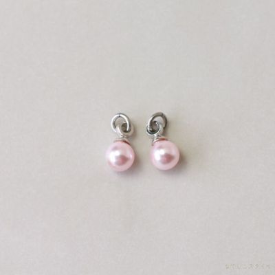 プラチナカラーの金具を使った桜色パールチャームを置いた画像
