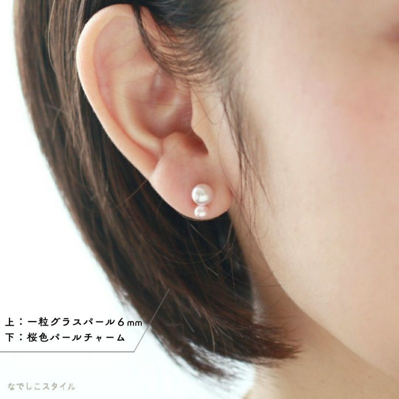 パールピアスに桜色パールチャームをつけた女性の耳画像