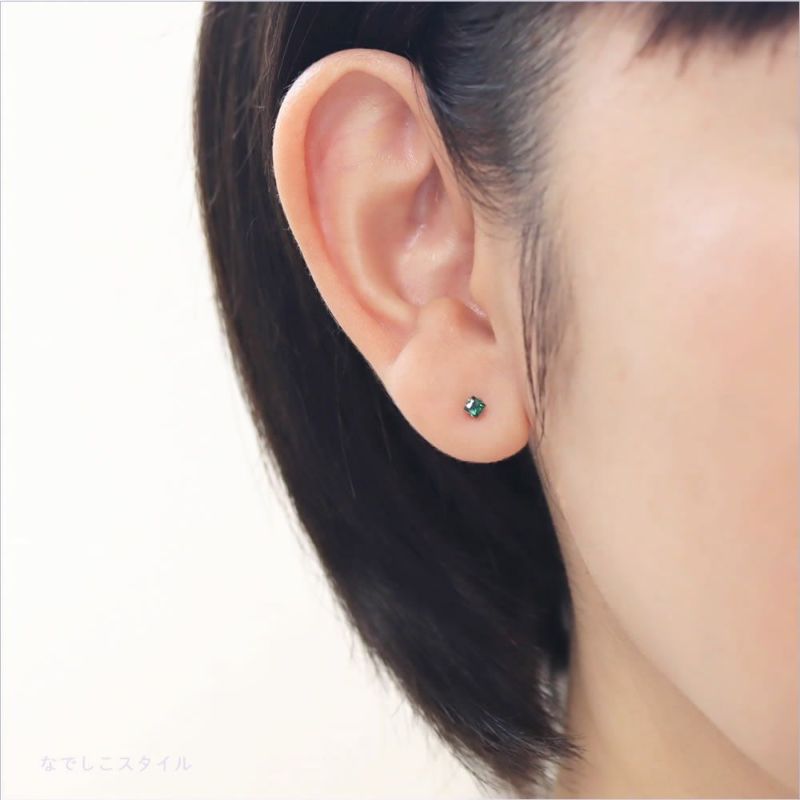 純チタンピアスひし形のカルテットエメラルド2.5ｍｍを着けた女性の耳の画像