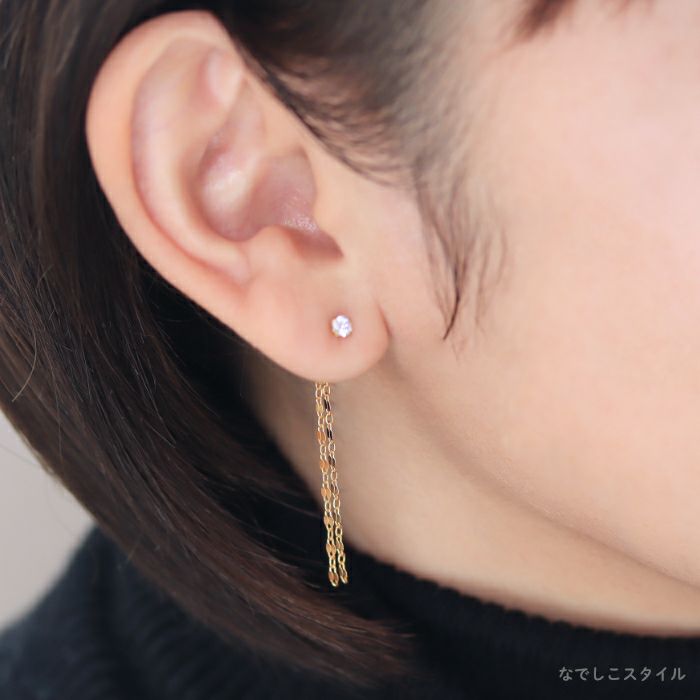 セカンドピアスのキャッチに着けられるフリンジチェーンバックキャッチのゴールドカラーを着けた４０代女性の耳もとを正面から見たイメージの画像