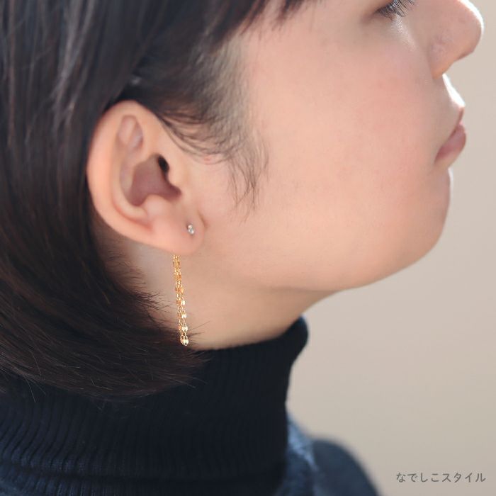セカンドピアスのキャッチに着けられるフリンジチェーンバックキャッチのゴールドカラーを着けた４０代女性の耳もとを後ろから見たイメージの画像