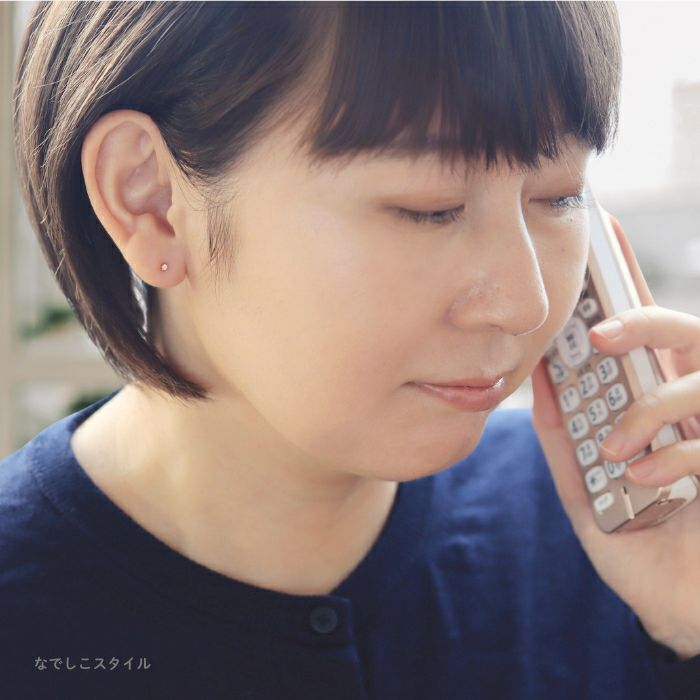 純チタンピアス、ゴールド軸の一粒キュービックジルコニアゴールドカラー「シャンパンダイア」２mmとバックキャッチを合わせて耳に着けている４０代女性のお出かけをイメージした画像